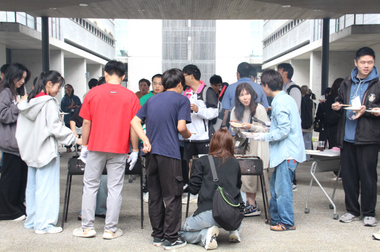 有朋会交流BBQ大会の様子：コンロを囲む同窓生と学生