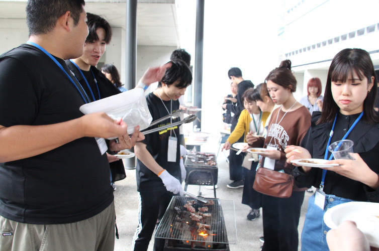 有朋会交流BBQ大会の様子：コンロを囲んでいる写真