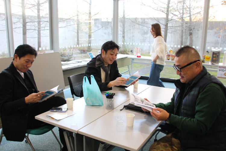 「りゅうか」サンプル本を読んでいる同窓生の写真